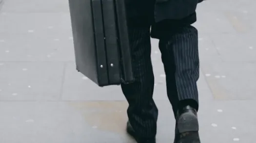 Person in a suit carrying a briefcase