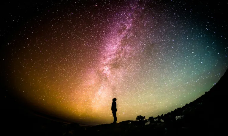 Image of a silhouette of a man stood with a universe behind him