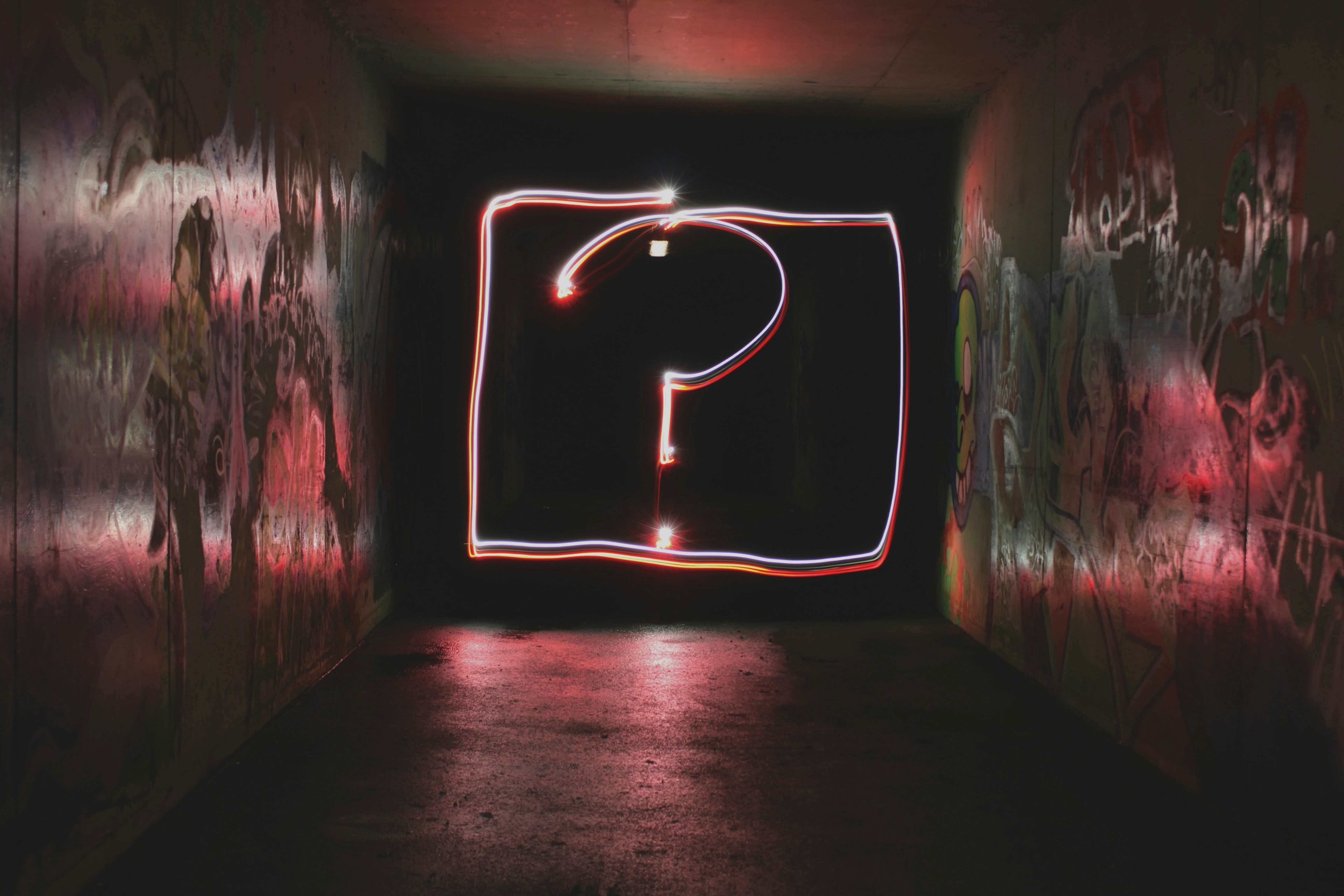 A light painting of a question mark in a dark corridor