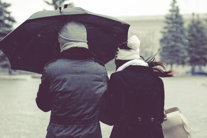 Man and woman under black umbrella