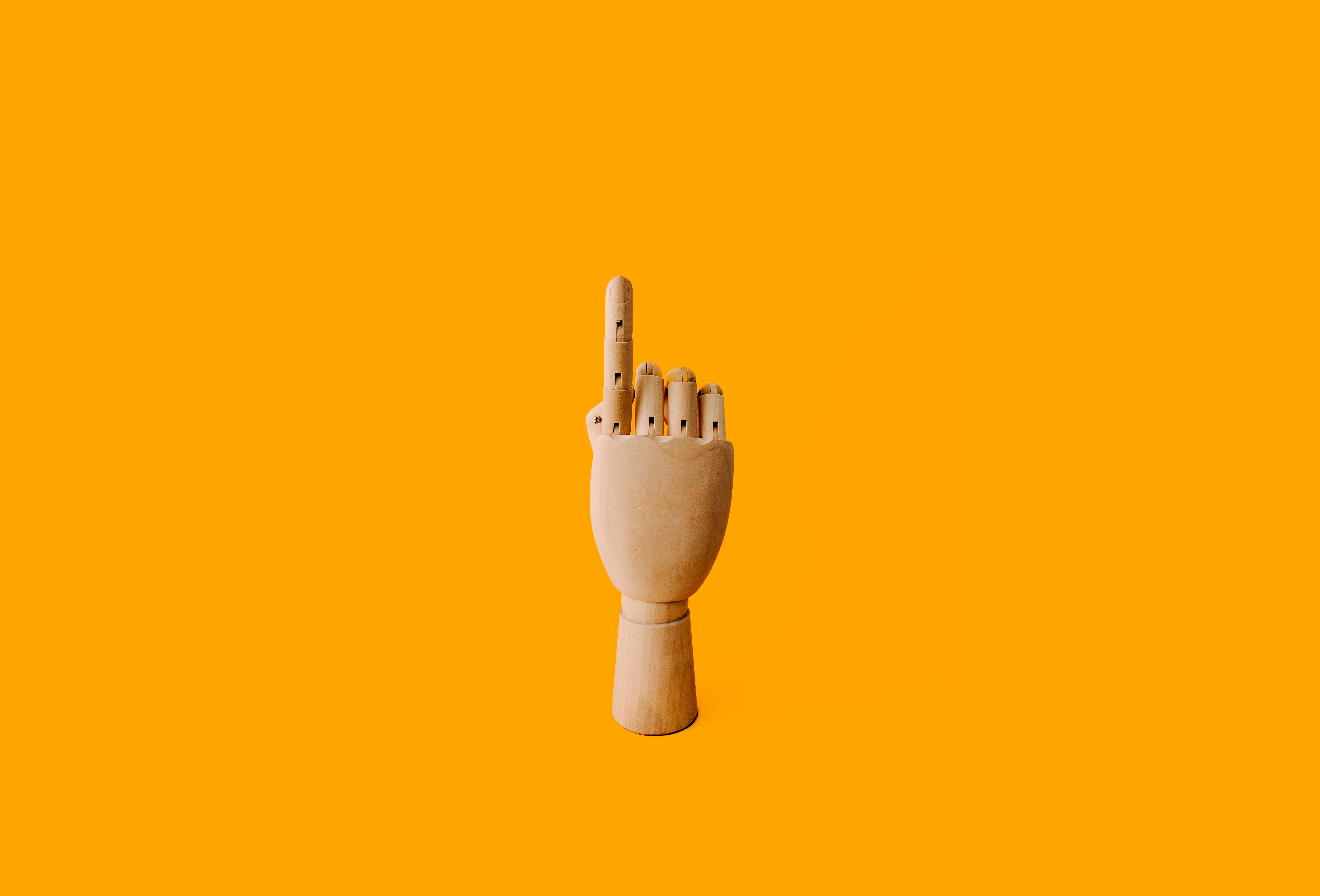 A wooden mannequin hand pointing up