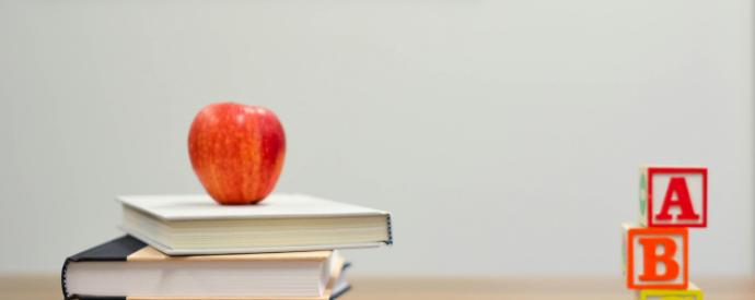 A stack of books, pencils, and abc blocks in a classroom