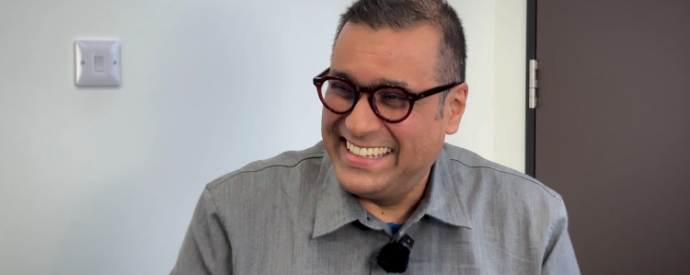 Gus - PI's executive director smiling in a video, tech pill logo in the bottom right corner