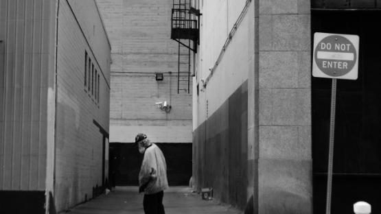 Man walking past alley in black and white
