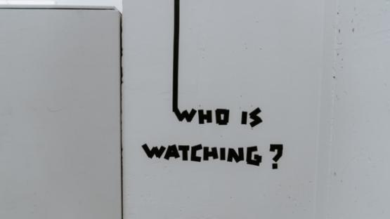Wall with who is watching painted on.