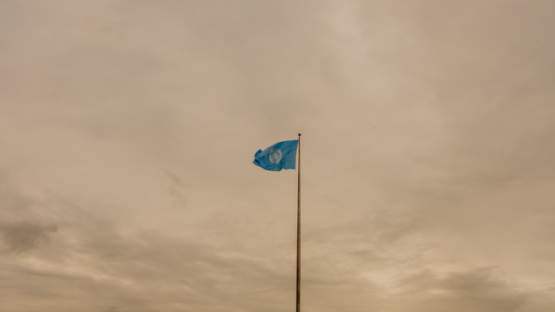 UN flag with cloudy sky in background