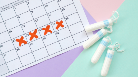 Tampons next to a calendar with red crosses marking a period