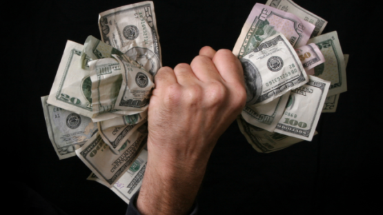A wad of money being grabbed in a hand