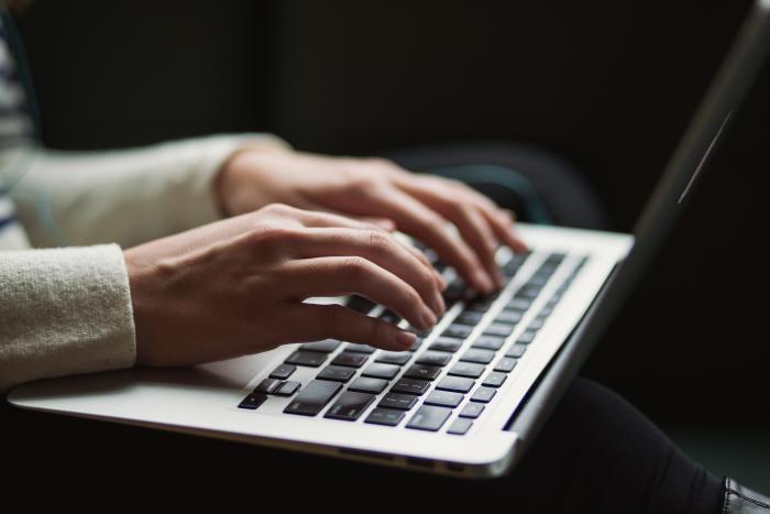 image of someone typing on laptop