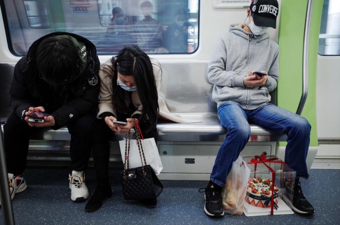 People using phones on public transport