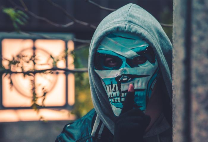 man wearing mask and hiding