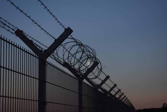 Photo of a border fence at night time