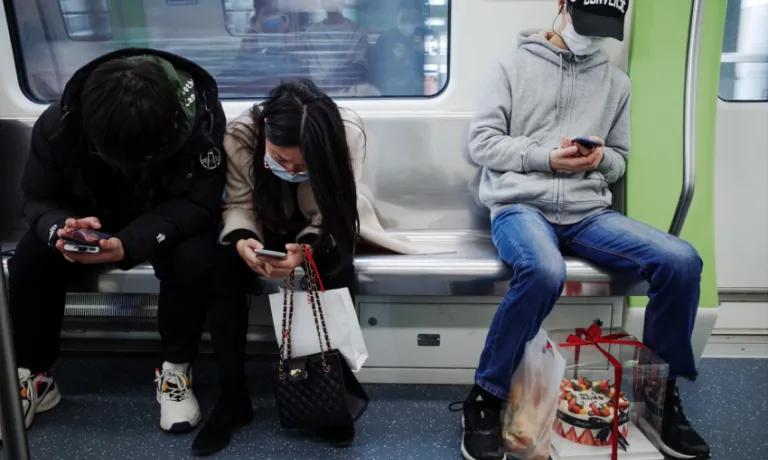 People using phones on public transport