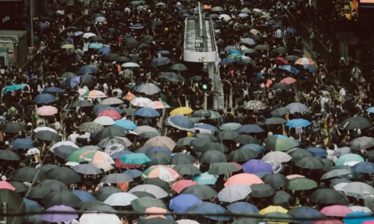 Crowds using umbrellas