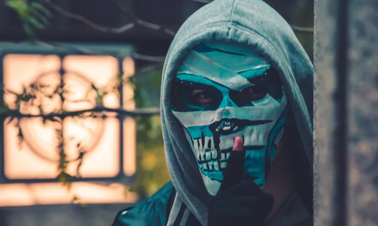 man wearing mask and hiding