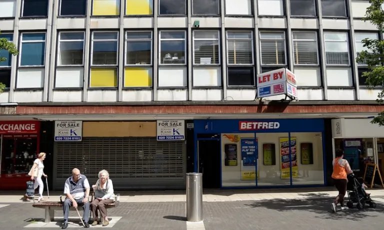 Couple sitting in front of shops in the UK