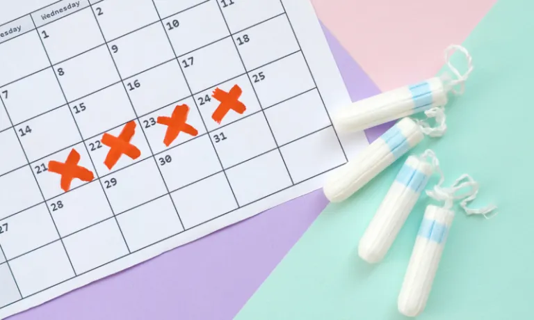 Tampons next to a calendar with red crosses marking a period
