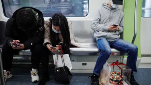 People using phones on public transport