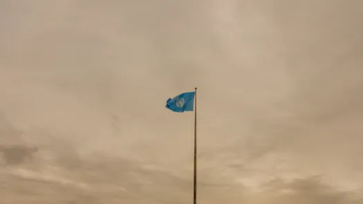 UN flag with cloudy sky in background