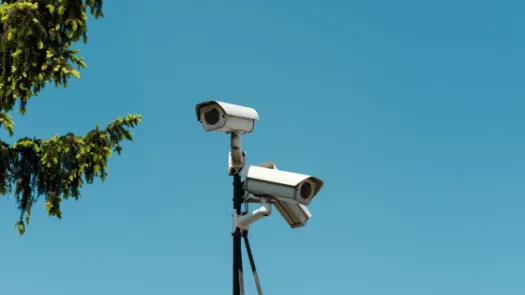 Tripod with surveillance cameras on blue sky background