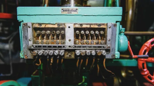 Teal and brown electric connector box with wires converging using screws, so quite aged