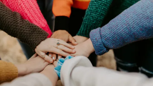 People in colourful sweaters holding hands