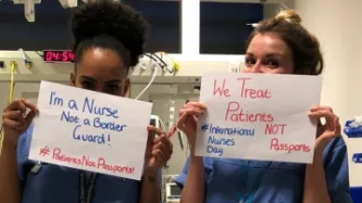 Nurses holding signs that say "We treat patients, not passports"