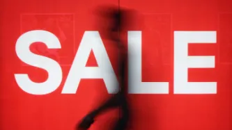 figure of a man in front of a window displaying the word "SALE"
