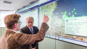 Dirk Vande Ryse, Head of the Frontex Situation Centre (FSC), on the left, giving explanations to Dimitris Avramopoulos, next to the screen of the FSC